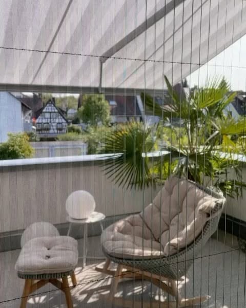 Plissee-Sichtschutz auf einem Balkon mit Loungesesseln